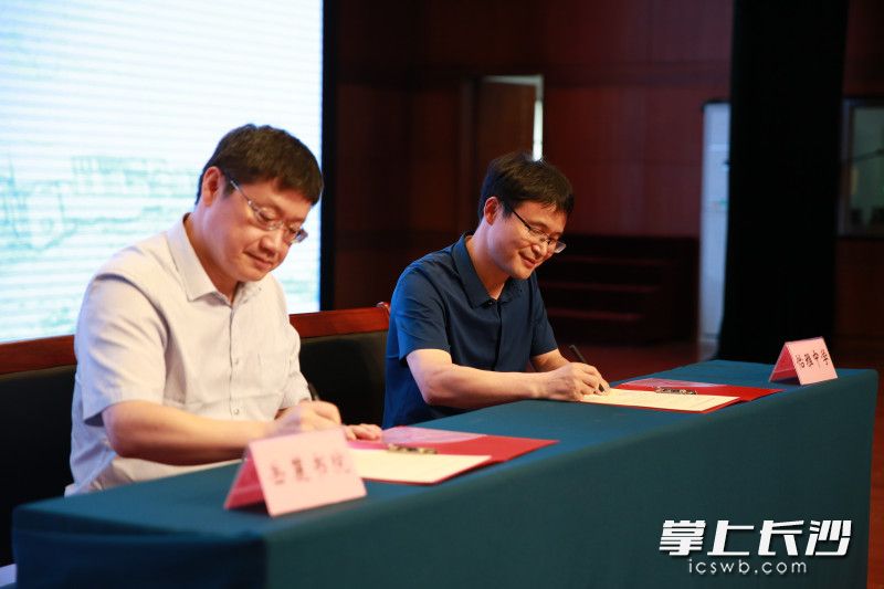 伟德国际1946官网院长肖永明和怡雅中学校长王良在合作协议书上签字。均为学校供图